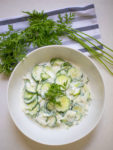 a bowl full of Old Fashioned Cucumber Salad with a napkin and garnish on the side