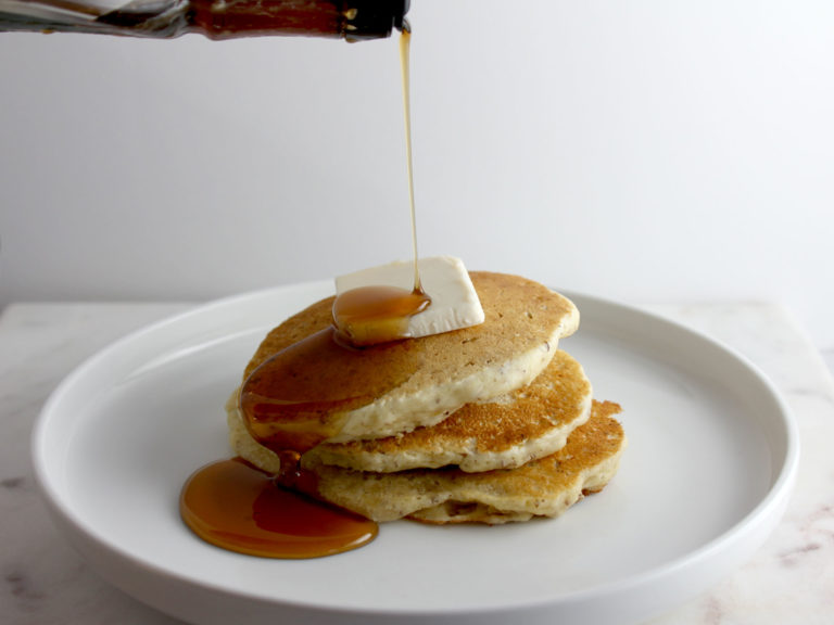Stack of three pancakes with butter and syrup
