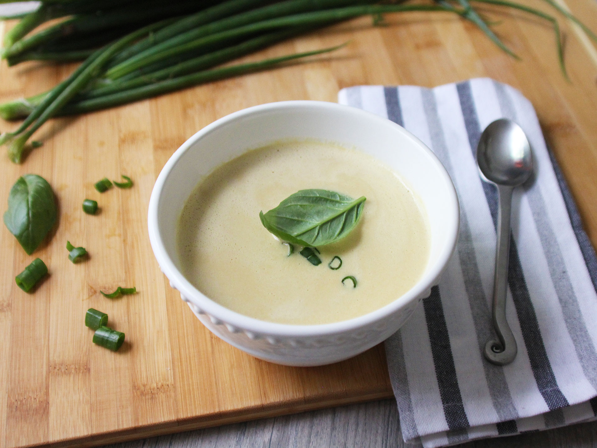 a bowl of Spring Onion Soup with green onion and basil on top