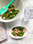 tabletop with a serving of Wilted Spinach Salad with Warm Apple Cider Vinegar Dressing
